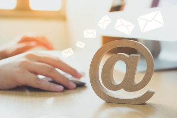 Email marketing concept, Hand using computer sending message with wooden email address symbol and envelope icon